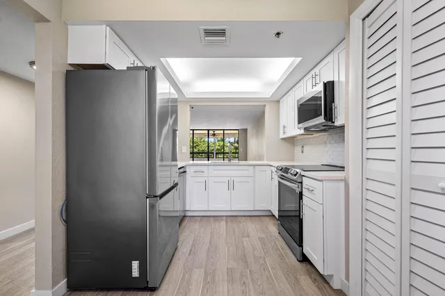 a kitchen with stainless steel appliances a refrigerator sink and stove top oven