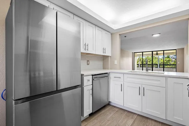 a kitchen with white cabinets and white appliances