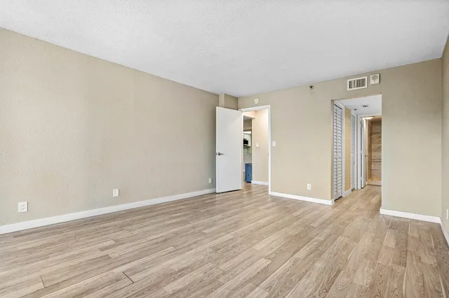 a view of an empty room with wooden floor
