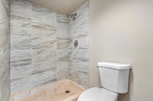 a bathroom with a toilet and a shower