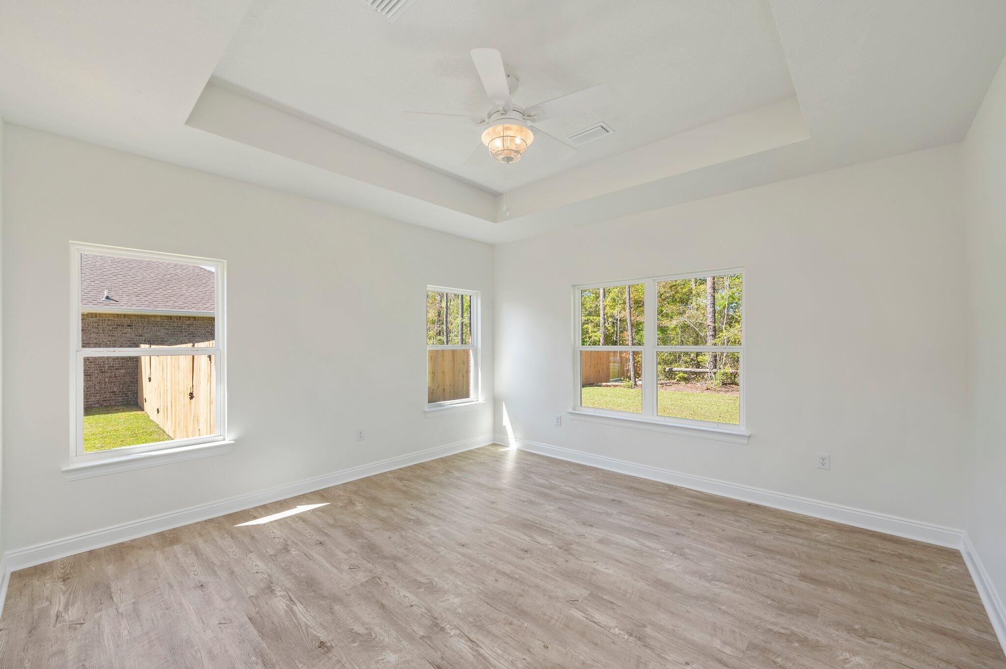 5448 Jenee Court Crestview, FL 32539 - Photo 17 of 42 a view of an empty room with a window and wooden floor