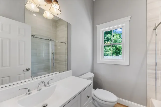a bathroom with a sink a toilet and shower