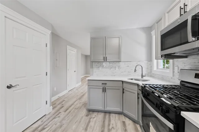 a kitchen with a sink stove and microwave
