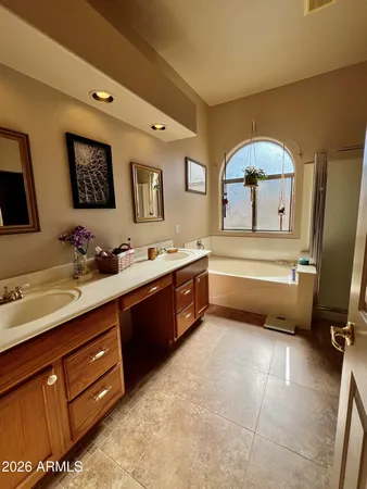 a spacious bathroom with a double vanity sink a mirror and a bathtub