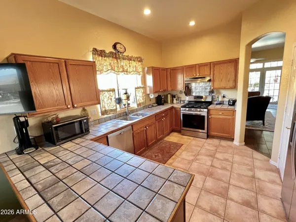 a kitchen with stainless steel appliances granite countertop a sink counter space cabinets and a stove