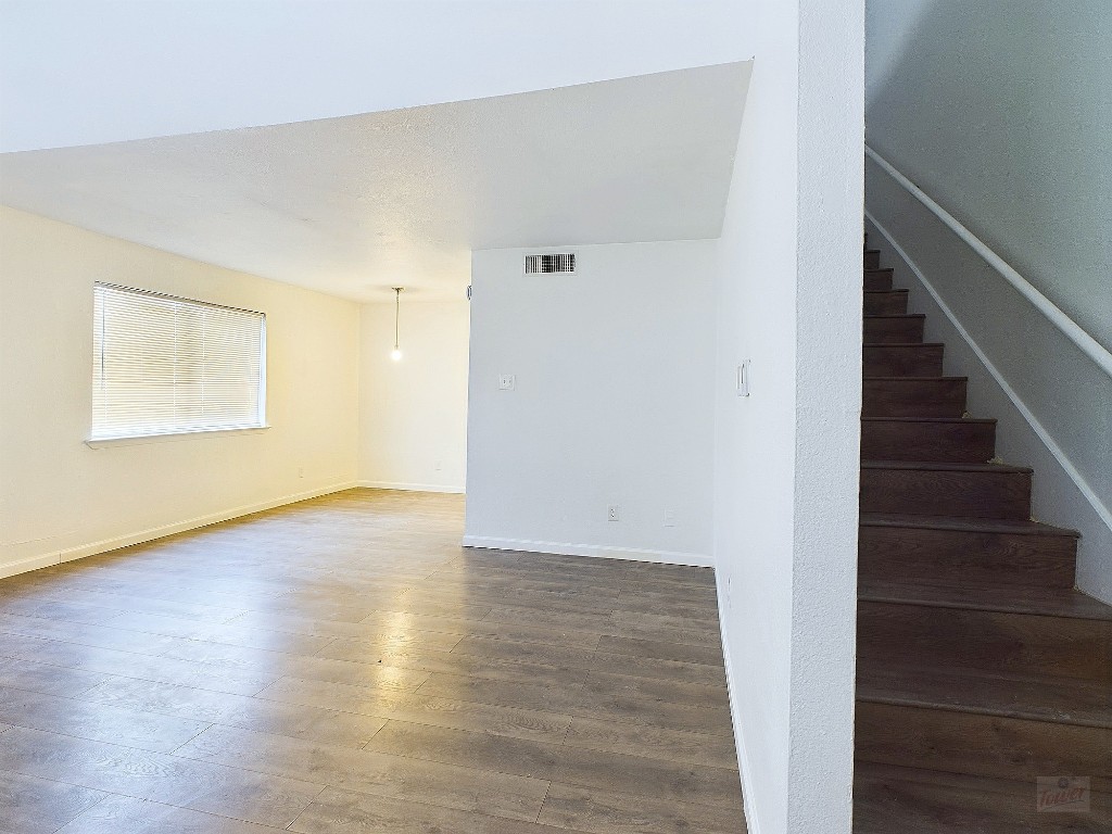 2124 Burton Drive, Unit 140 Austin, TX 78741 - Photo 12 of 22 a view of an empty room with wooden floor and entryway
