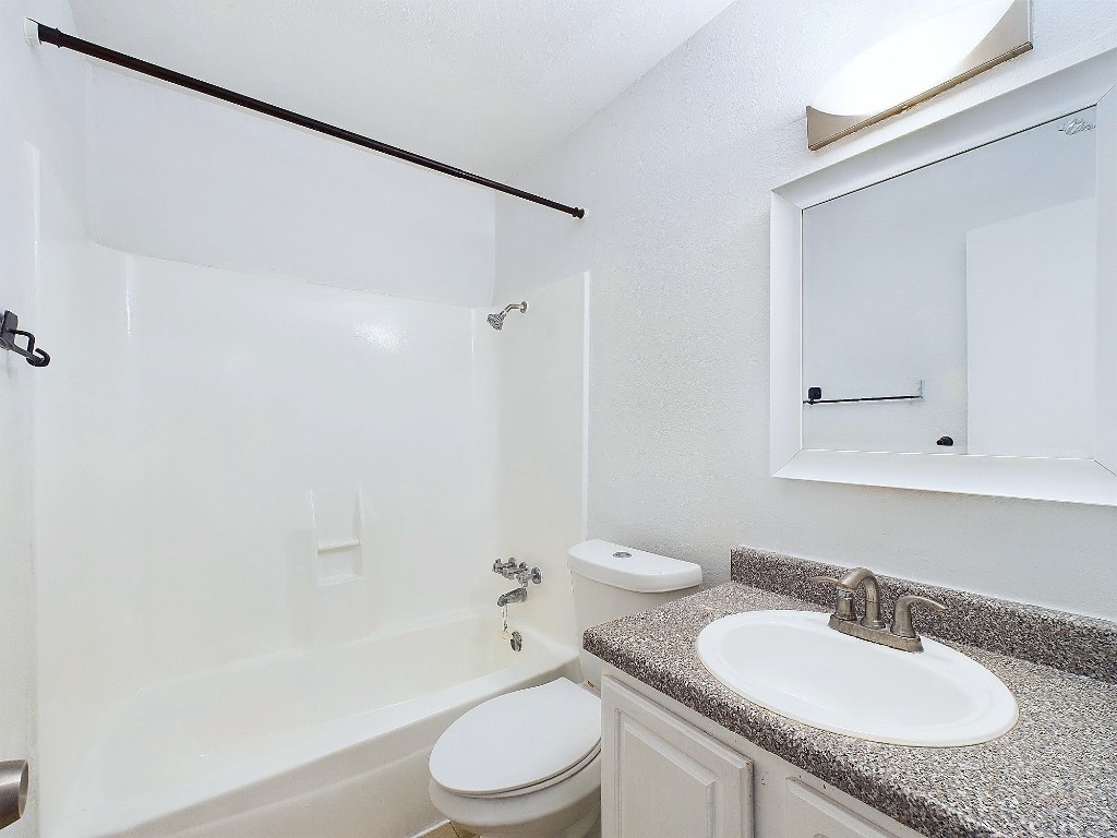 2124 Burton Drive, Unit 140 Austin, TX 78741 - Photo 17 of 22 a bathroom with a granite countertop sink toilet and shower