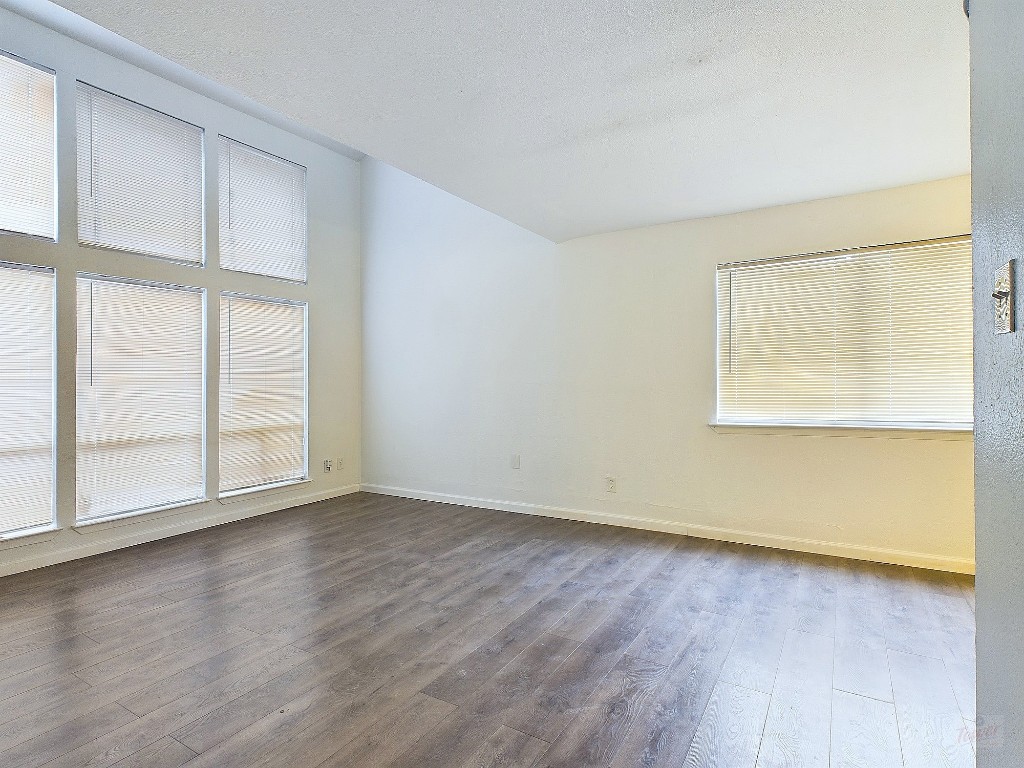 2124 Burton Drive, Unit 140 Austin, TX 78741 - Photo 2 of 22 an empty room with wooden floor and windows