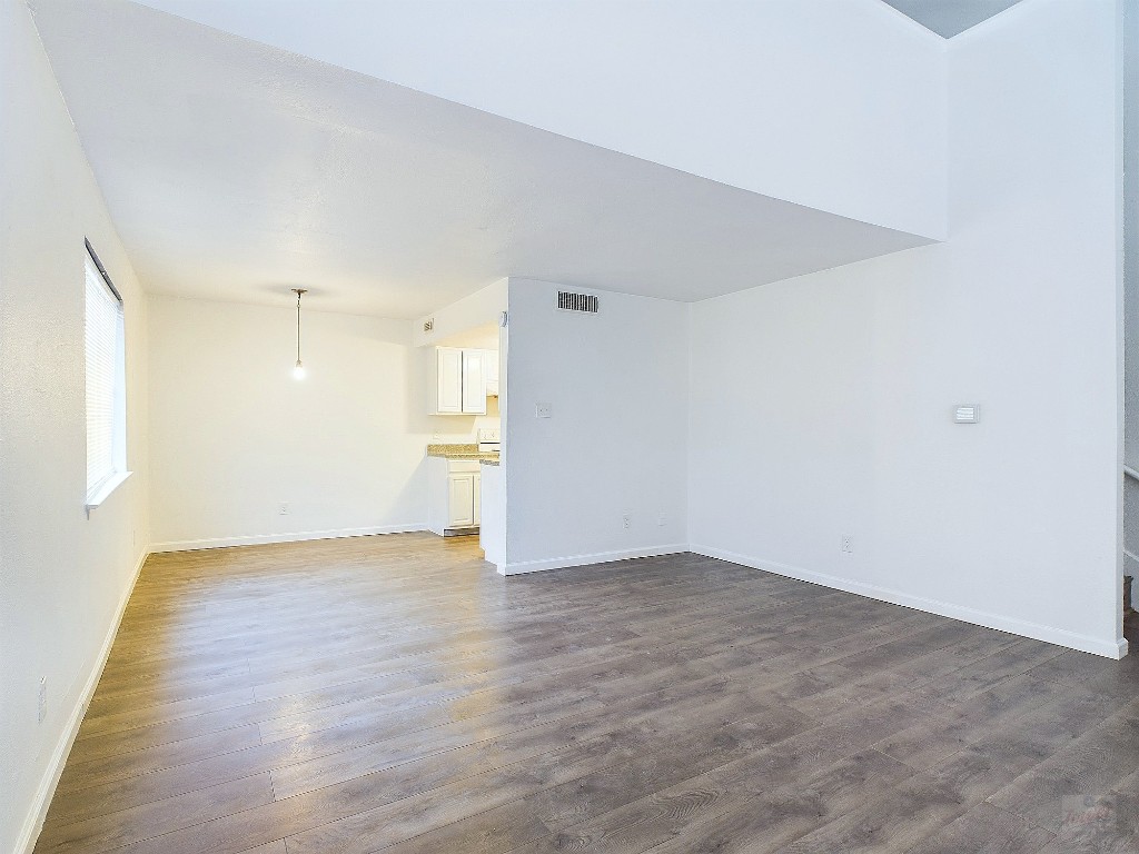 2124 Burton Drive, Unit 140 Austin, TX 78741 - Photo 3 of 22 a view of an empty room with wooden floor and a window
