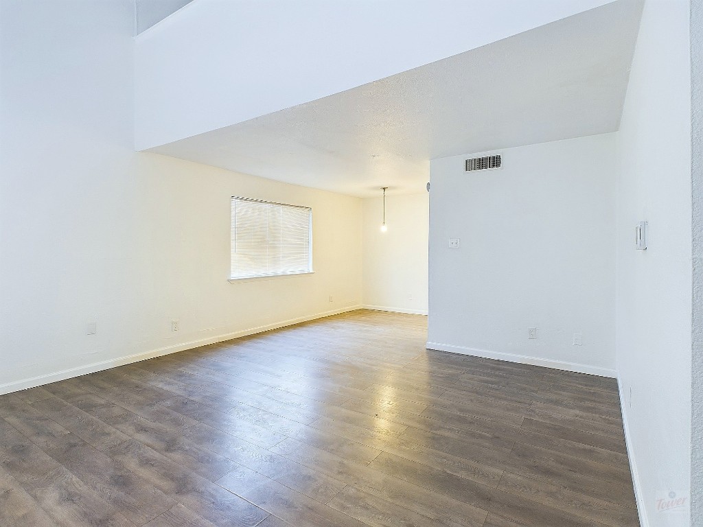 2124 Burton Drive, Unit 140 Austin, TX 78741 - Photo 6 of 22 an empty room with wooden floor and windows