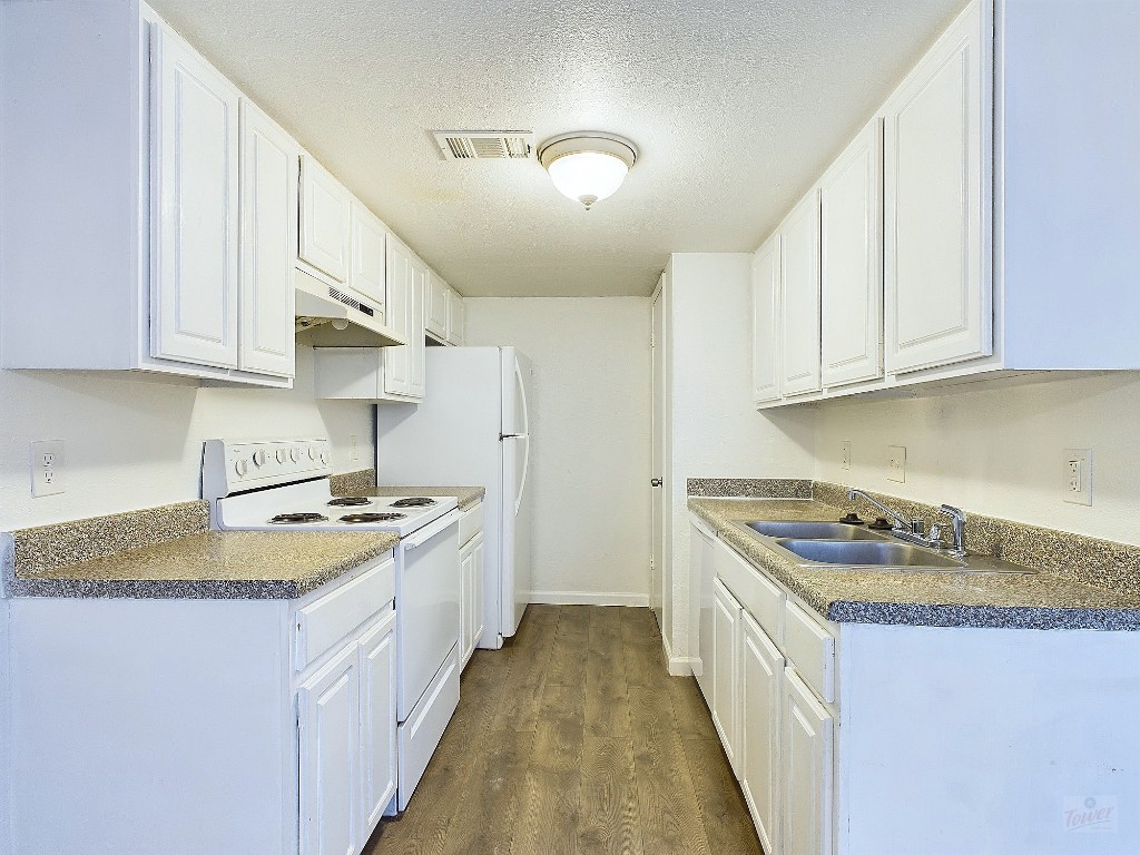 2124 Burton Drive, Unit 140 Austin, TX 78741 - Photo 8 of 22 a kitchen with a stove a sink a refrigerator and cabinets
