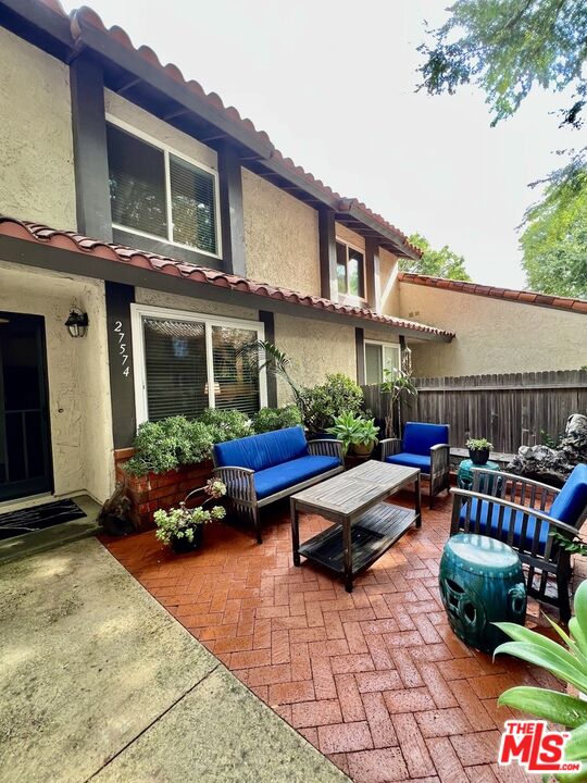 a view of patio with a table and chairs and plants