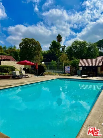 a view of a garden with swimming pool and outdoor seating
