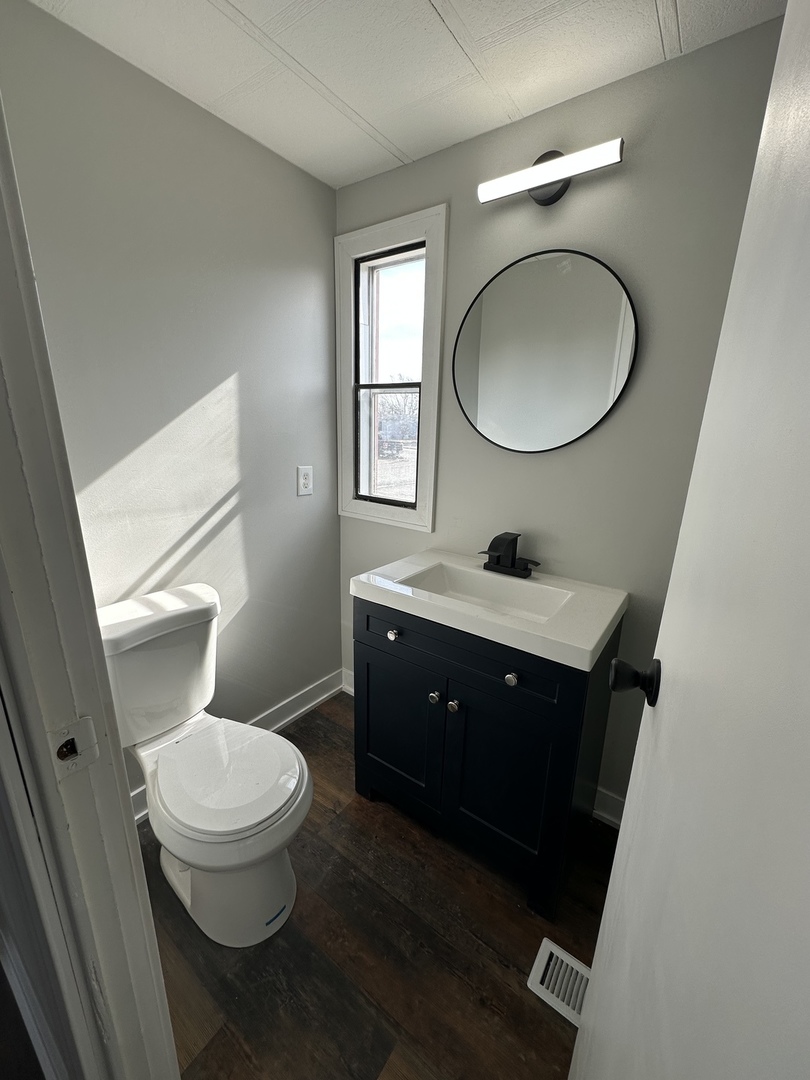 11 Hearthside Drive Matteson, IL 60443 - Photo 9 of 10 a bathroom with a toilet a sink a mirror and a window