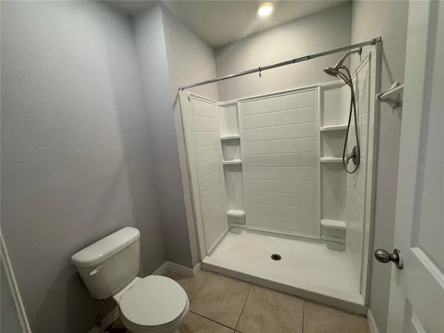 a bathroom with a shower a toilet and sink
