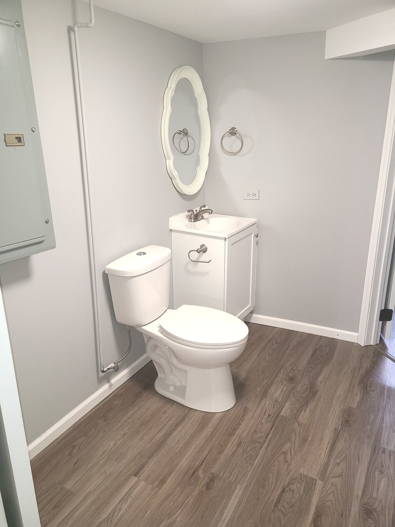 1045 North 9th Street Rochelle, IL 61068 - Photo 9 of 27 a white toilet sitting next to a wooden cabinets