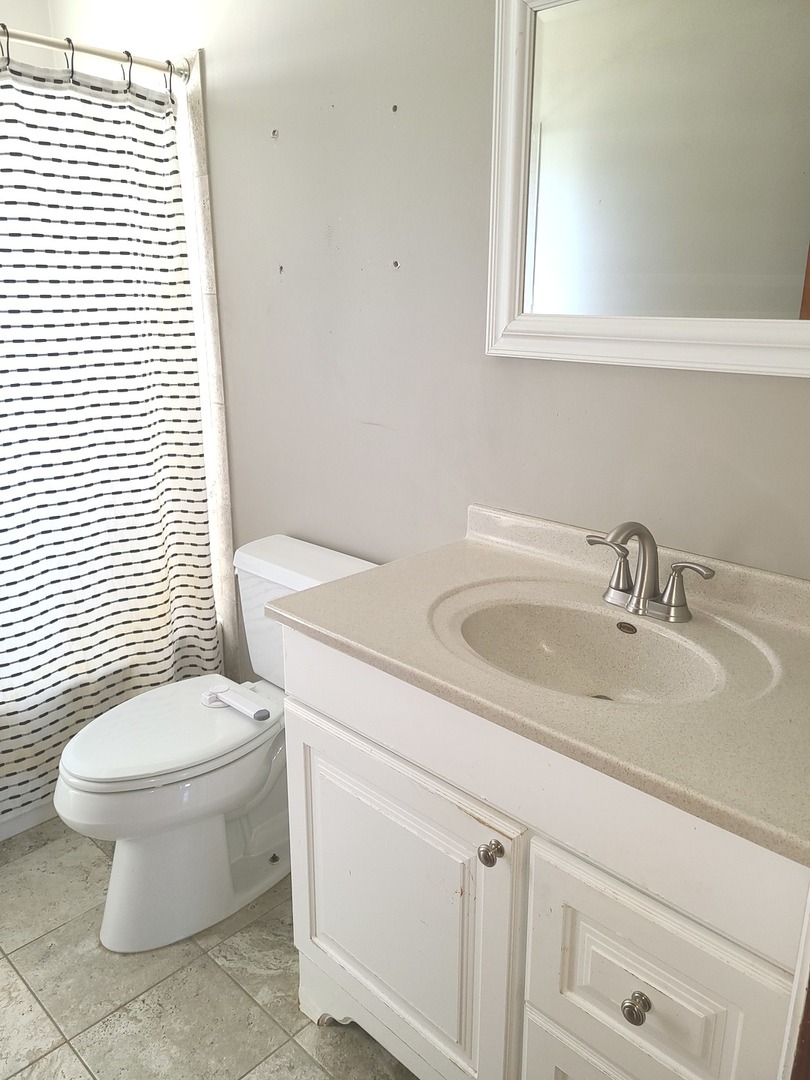 1045 North 9th Street Rochelle, IL 61068 - Photo 10 of 27 a white toilet sitting next to a bathroom sink
