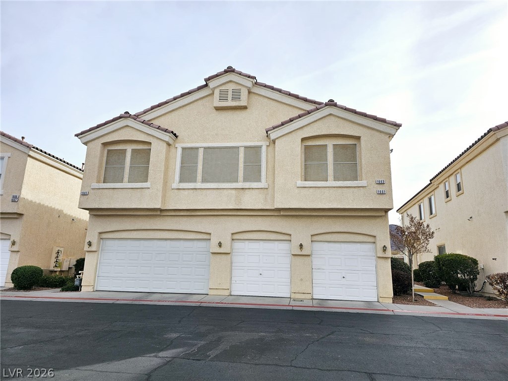 1663 Lefty Garcia Way Henderson, NV 89002 - Photo 29 of 31 A well-maintained stucco exterior offers a welcoming façade and three separate garage entrances.