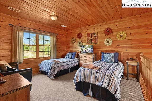 a bedroom with two beds and a large window