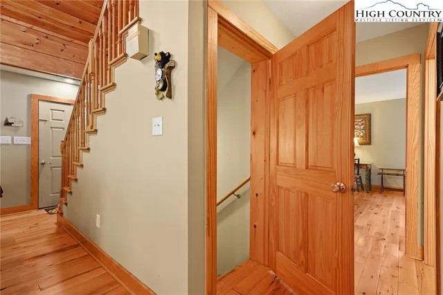 a view of a hallway with wooden floor and staircase