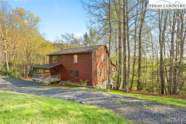 a view of a house with backyard and a tree