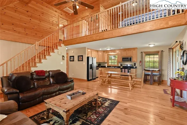 a living room with furniture a rug and kitchen view