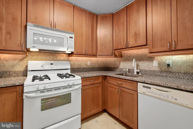 a kitchen with granite countertop cabinets stainless steel appliances and sink