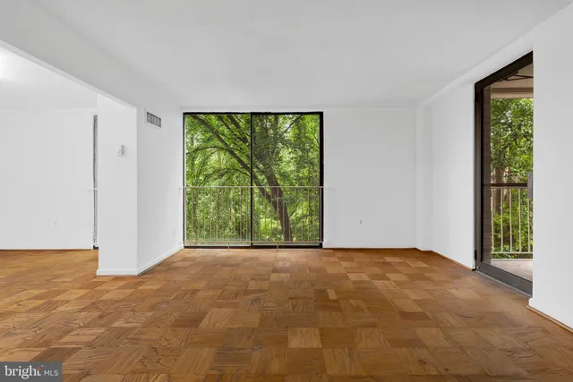 a view of an empty room with large windows