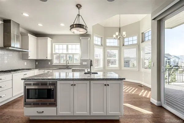 a kitchen with stainless steel appliances granite countertop a stove and a wooden floors
