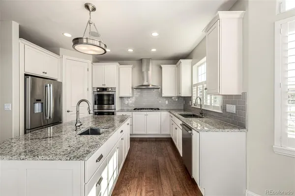 a kitchen with stainless steel appliances granite countertop a sink stove and refrigerator