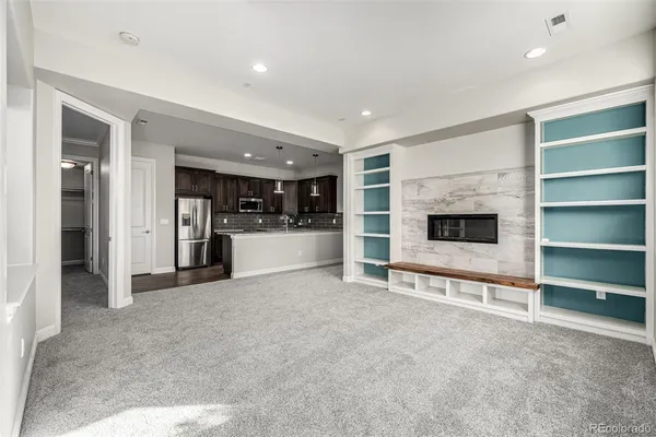a view of livingroom with an empty space and kitchen view