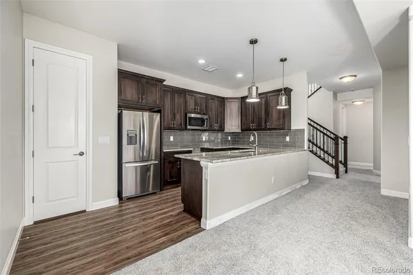 a large kitchen with a refrigerator and a stove top oven