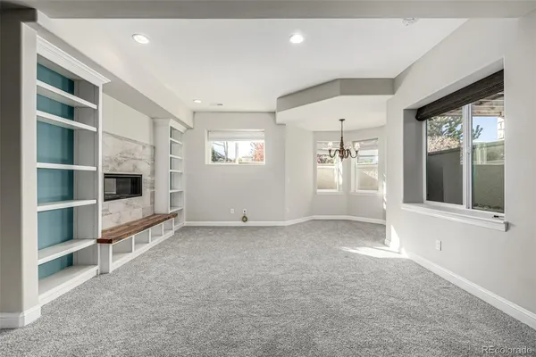 a view of an empty room with a window and a kitchen