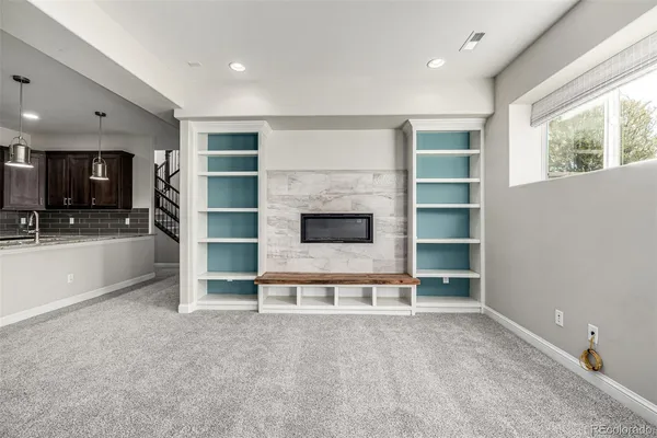 an empty room with a fireplace cabinet and window