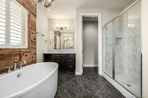 a bathroom with a tub a sink and a large mirror