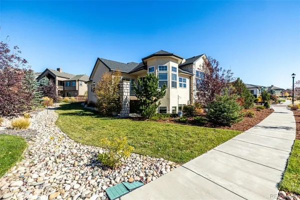 a front view of a house with a yard and trees