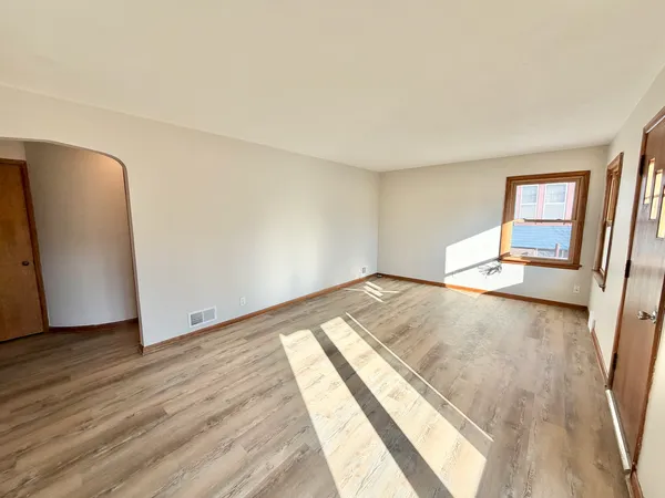 a view of a room with wooden floor and a window