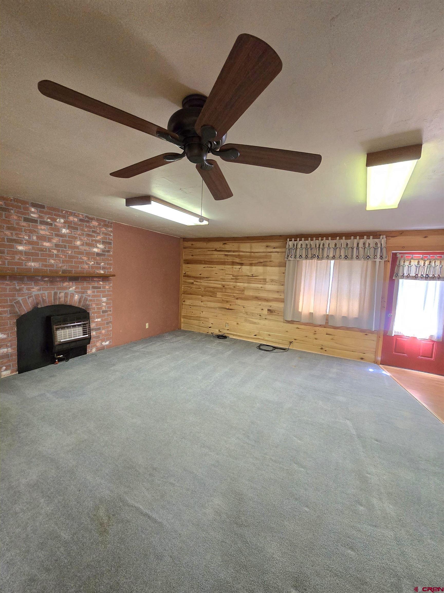 23435 County Rd M Cortez, CO 81321 - Photo 3 of 27 a view of an empty room with a fireplace and a window