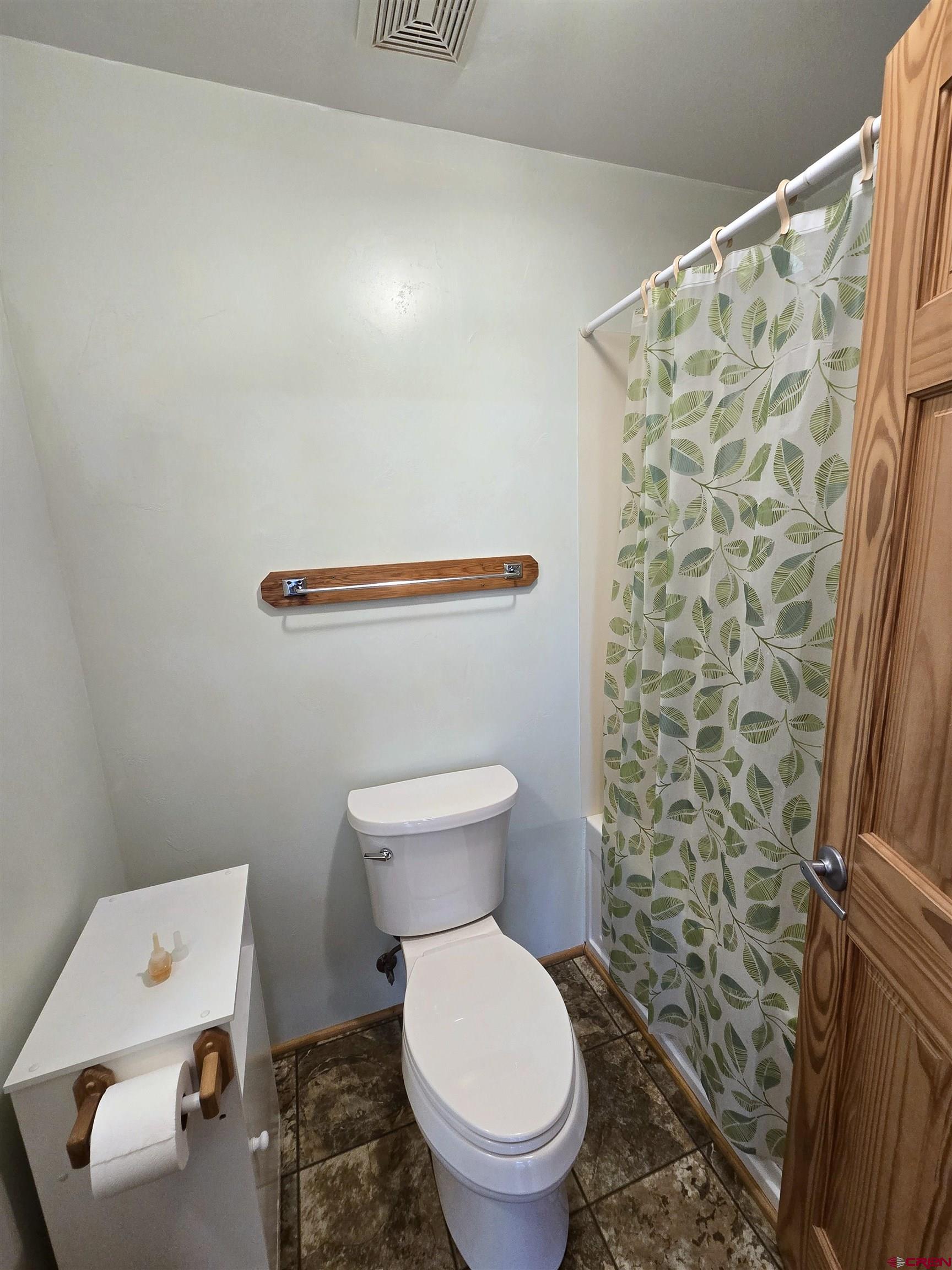 23435 County Rd M Cortez, CO 81321 - Photo 9 of 27 a white toilet sitting next to a shower curtain