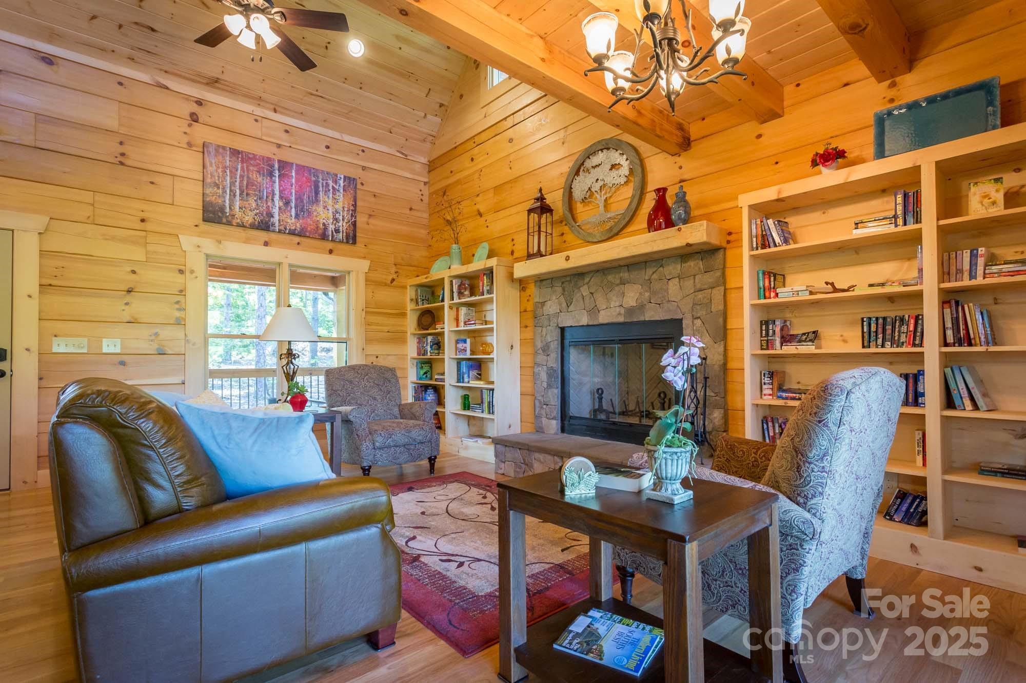 9587 Shortoff View Terrace, Unit 57 Nebo, NC 28761 - Photo 13 of 16 a living room with furniture a fireplace and a chandelier