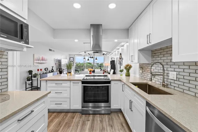a kitchen with granite countertop a sink stainless steel appliances and cabinets