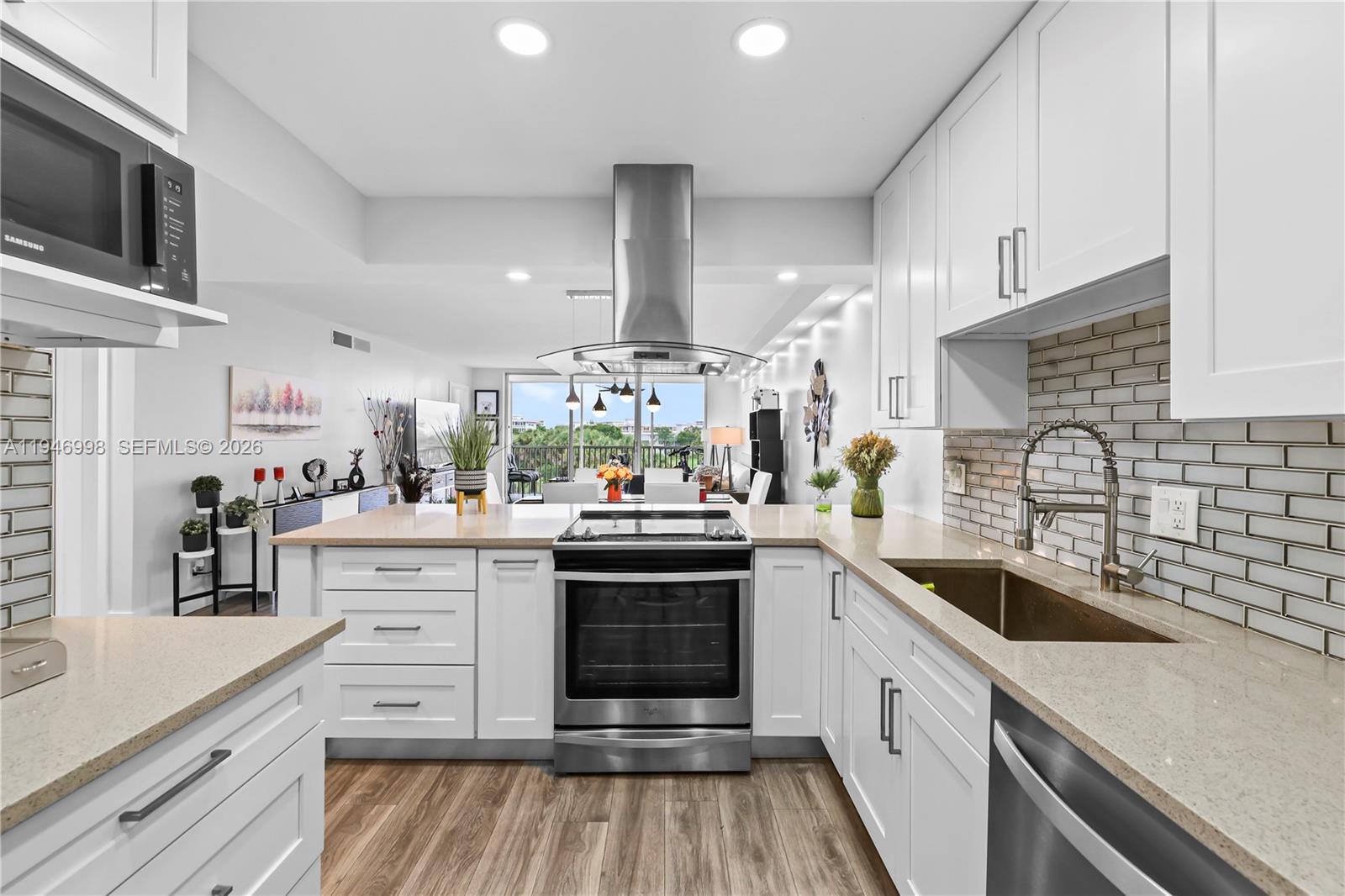 a kitchen with granite countertop a sink stainless steel appliances and cabinets