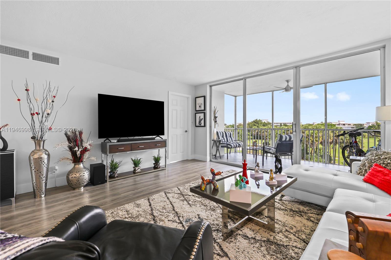 2661 South Course Drive, Unit 510 Pompano Beach, FL 33069 - Photo 13 of 49 a living room with furniture and a flat screen tv