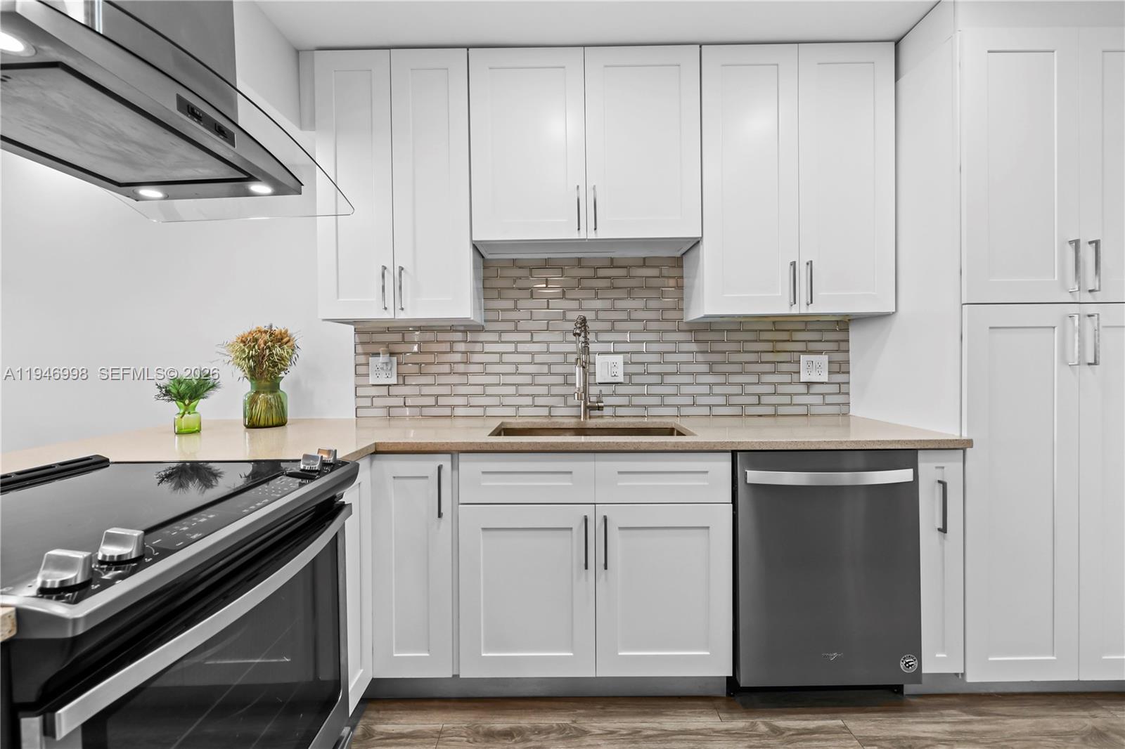 2661 South Course Drive, Unit 510 Pompano Beach, FL 33069 - Photo 2 of 49 a kitchen with granite countertop a sink stainless steel appliances and white cabinets