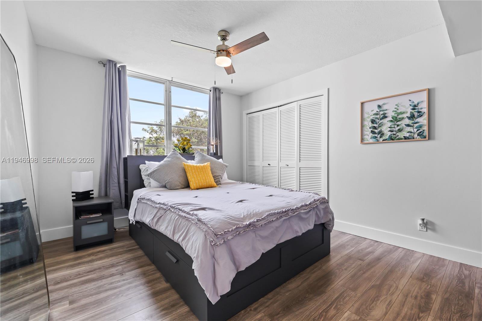 2661 South Course Drive, Unit 510 Pompano Beach, FL 33069 - Photo 24 of 49 a bedroom with a bed a large window with wooden floor