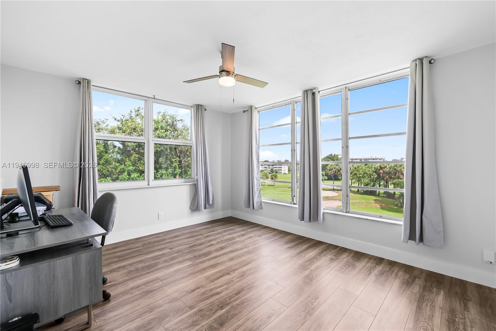 2661 South Course Drive, Unit 510 Pompano Beach, FL 33069 - Photo 27 of 49 a view of an empty room with a window and wooden floor
