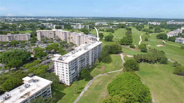 an aerial view of residential houses with outdoor space and trees