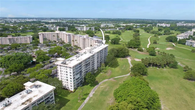 an aerial view of residential houses with outdoor space and trees