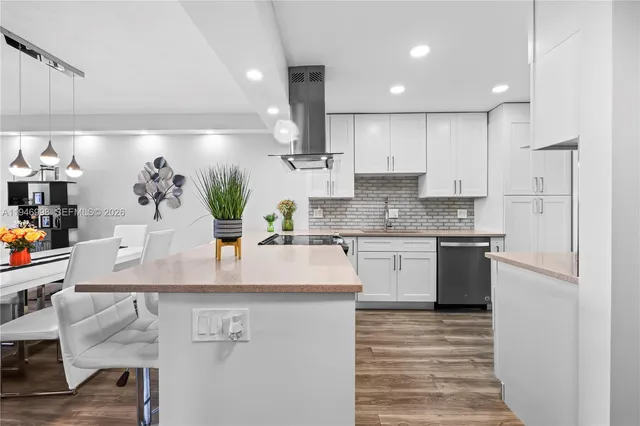 a kitchen with kitchen island granite countertop a sink a counter space appliances and cabinets