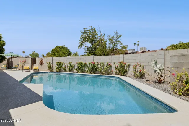 a view of a swimming pool with outdoor seating and lake view